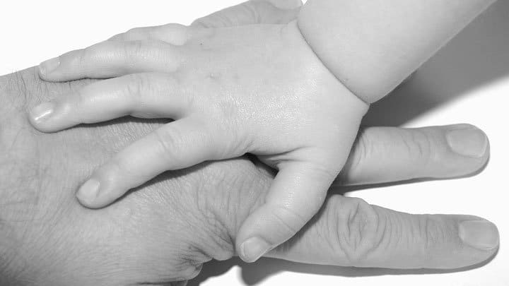 Baby hand on top of fathers hand