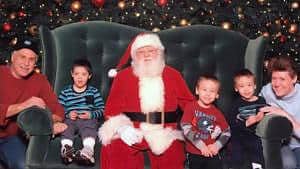 Identical twins with family and Santa