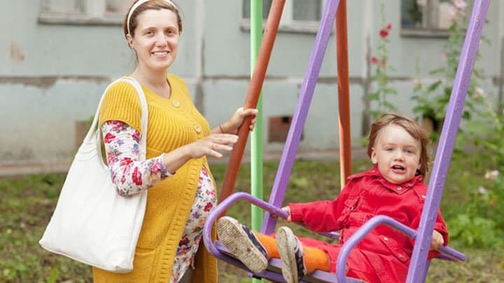 regnant mother with child on swing